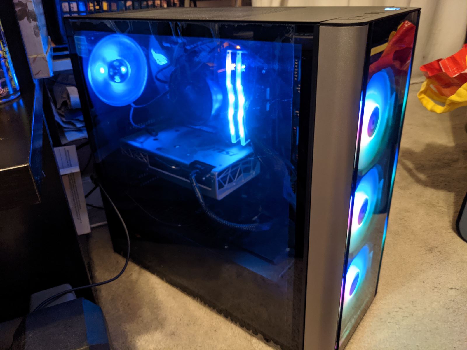 A finished PC tower with tempered glass panels, lit in blue.