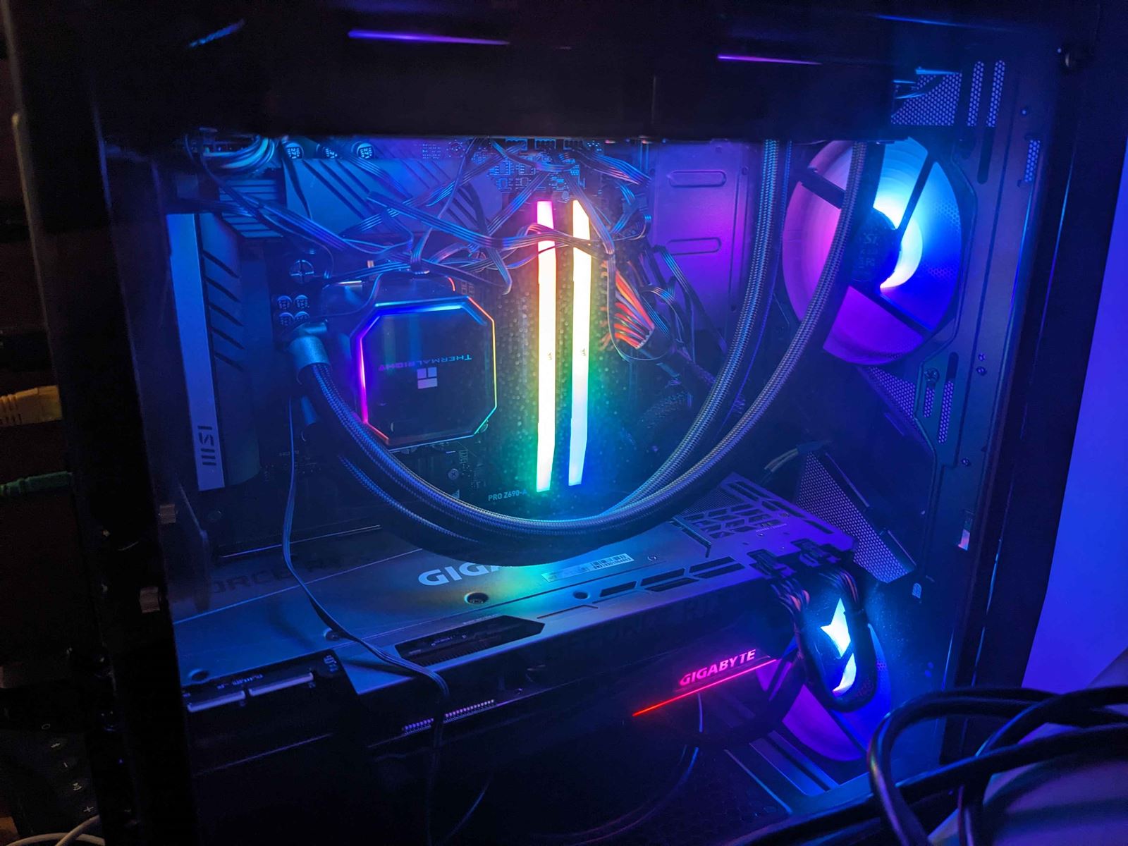 Inside a dark PC case lit in purple and blue: a liquid cooler, RGB memory and a Gigabyte graphics card.