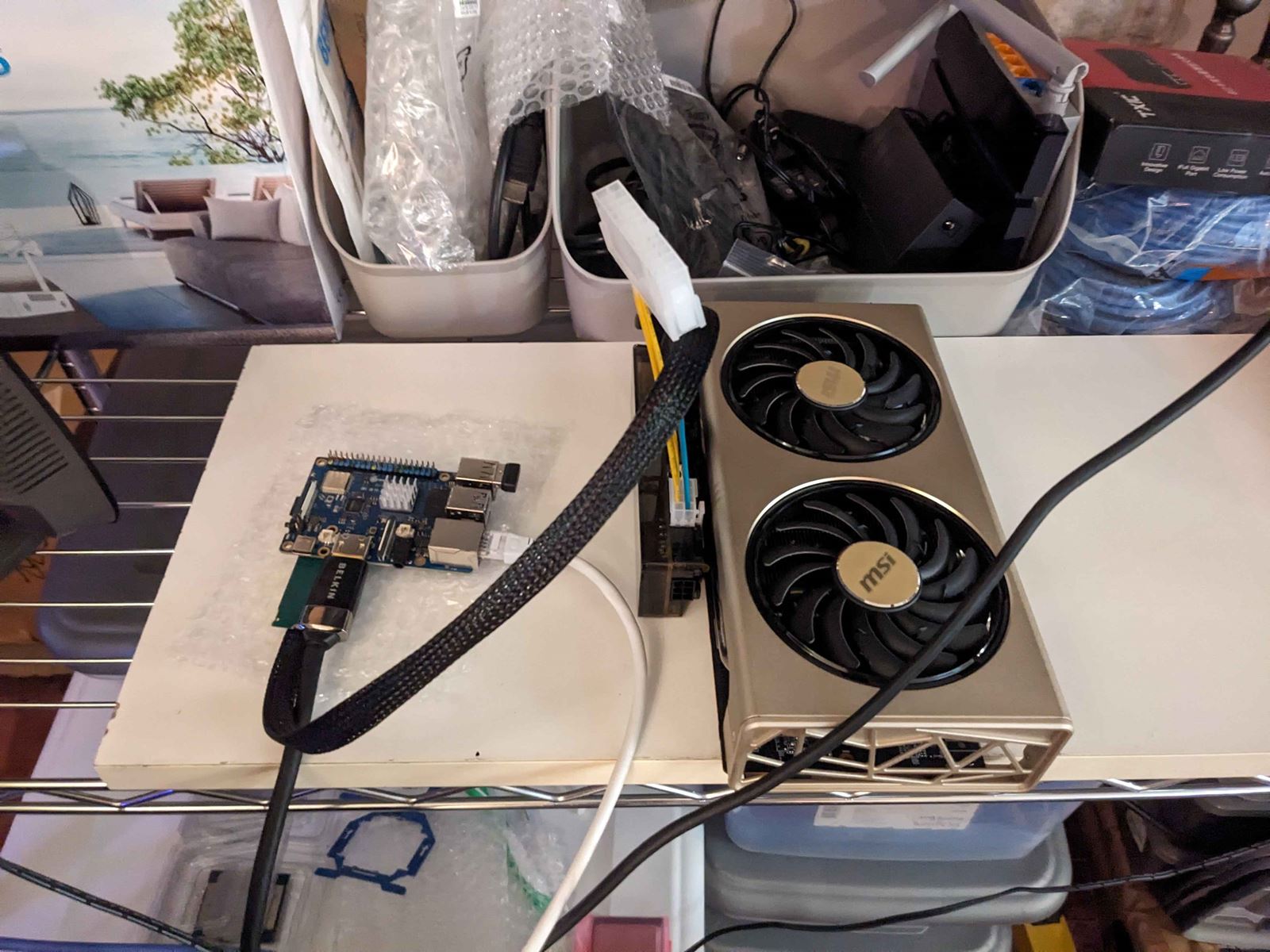 An MSI graphics card on a shelf, cabled to a small single-board computer beside it.